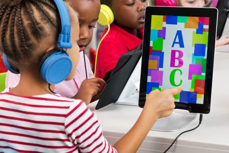 Students learning alphabet with digital tablets