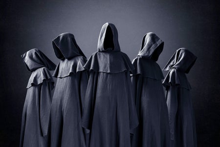 Group of five scary figures with no faces in hooded cloaks in the dark