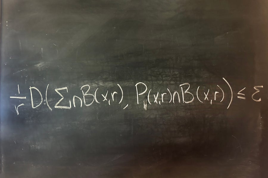 Math equation written in white on a black board.