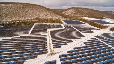 Solar panels in flat landscape with mountains in background