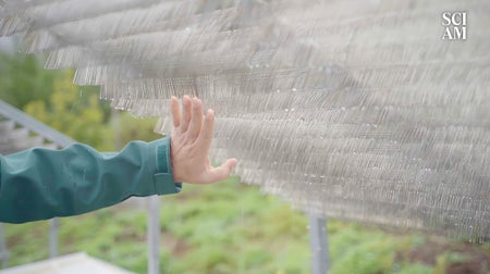 A hand brushes over a set of metal needles that are covered in moisture