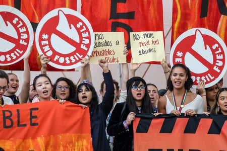 Young activist stage the last protest in COP28 conference venue with END FOSSIL FUEL signs.