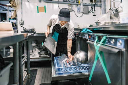 Restaurant staff unloading dishwasher