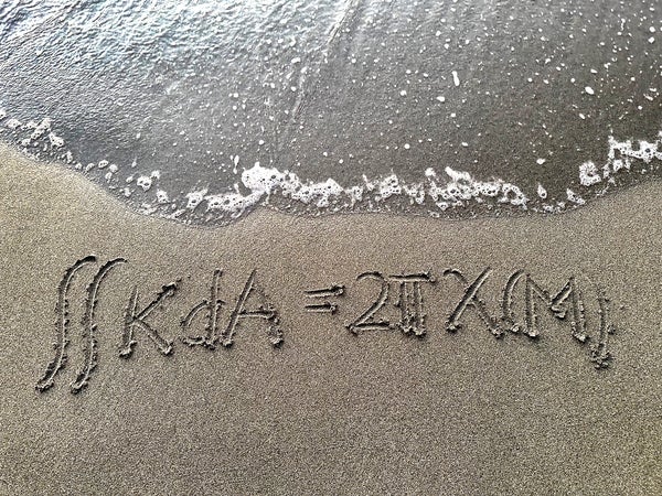 Math equation written in sand.