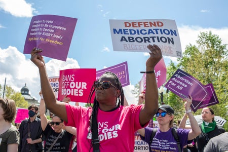 Abortion rights activists holding signs at a rally.