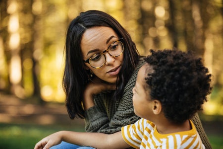 Mother talking to young son outdoors