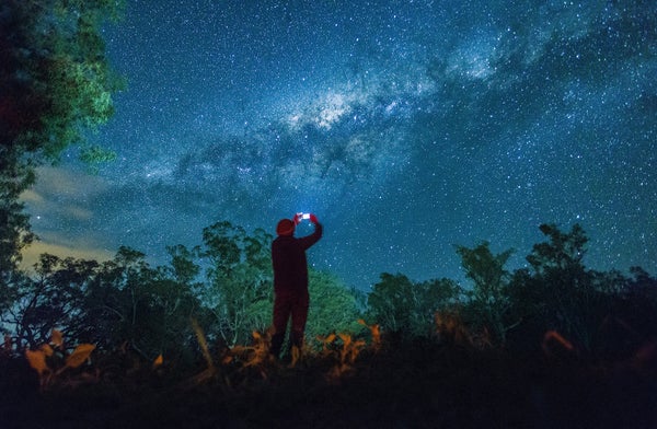 Man taking photo of night sky with smartphone