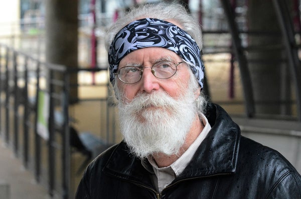 A portrait of a bearded man wearing glasses and a bandana.